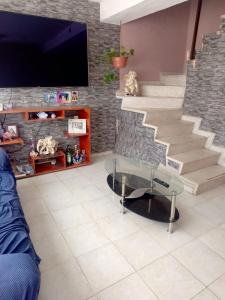 a living room with a glass coffee table and stairs at House near AIFA in San Cristóbal
