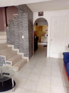 a living room with a staircase and a brick wall at House near AIFA in San Cristóbal
