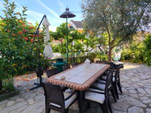 a table with chairs and an umbrella on a patio at Casa Os Maias - Jardim, terraço e espaço para 10 pessoas in Mirandela
