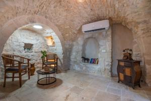a stone room with two chairs and a table at Tirat Ronit - טירת רונית in Safed