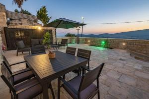 a wooden table with chairs and an umbrella on a patio at Tirat Ronit - טירת רונית in Safed