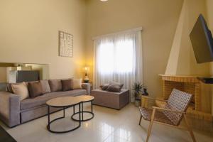 a living room with a couch and a table at Villa Kalymnos by Villa Plus in Kolymbia