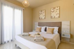 a bedroom with a large bed with towels on it at Villa Kalymnos by Villa Plus in Kolymbia +16 photos
