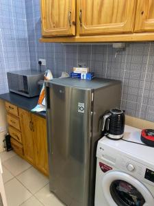 a kitchen with a refrigerator and a washing machine at The Senegambia Hideaway in Amdalai