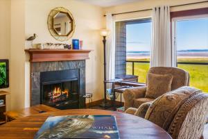 a living room with a fireplace and a table at Hi-Tide Resort Queen Bed Unit 29 in Moclips