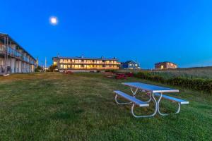 a picnic table in a field in front of a building at Hi-Tide Resort Queen Bed Unit 29 in Moclips