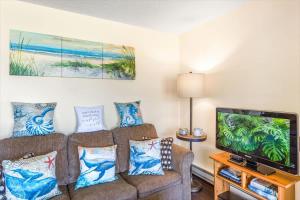 a living room with a couch and a flat screen tv at Hi-Tide Resort Queen Bed Unit 29 in Moclips