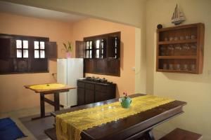 a kitchen with a table and a refrigerator at Morada Coral Hostel em Maracaípe in Porto De Galinhas +40 photos