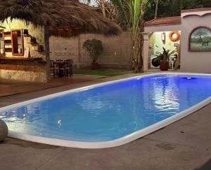 a large blue swimming pool in a backyard at Hotel El Texcalame in Lo de Marcos