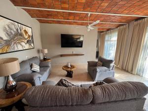 a living room with a couch and chairs and a ceiling at Hotel El Texcalame in Lo de Marcos