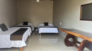 a room with three beds and a bench in it at Hotel El Texcalame in Lo de Marcos +13 photos