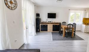 a living room with a table and a clock on the wall at Vikendica Sana in Sanski most