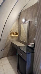 a bathroom with a counter with a mirror and a sink at Wadi Rum Dome Camp in Disah +86 photos