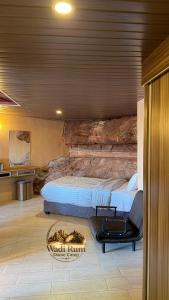 a bedroom with a bed and a chair in it at Wadi Rum Dome Camp in Disah