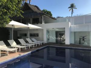 a villa with a swimming pool and chairs and a house at Luxury Villa by the Lake in Tequesquitengo