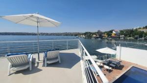 a boat deck with chairs and an umbrella and a table at Luxury Villa by the Lake in Tequesquitengo +34 photos