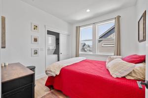 a bedroom with a red bed and a window at Modern Loft Private Golf Course Retreat in Post Falls