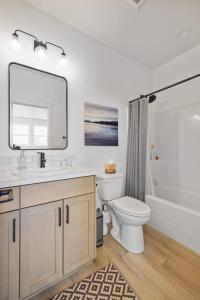 a bathroom with a sink and a toilet and a mirror at Modern Loft Private Golf Course Retreat in Post Falls