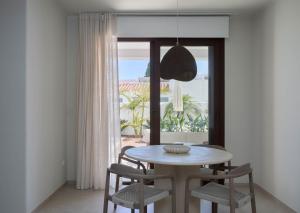 a dining room with a table and chairs and a window at Ananda Mojácar - Only Adults in Mojácar