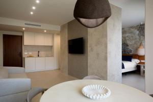 a living room with a white table and a kitchen at Ananda Mojácar - Only Adults in Mojácar