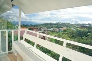a white balcony with a view of a town at Little hut in Kampong Kundassan