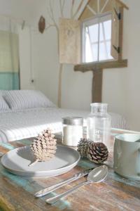 a table with a plate and pine cones on it at Little hut in Kampong Kundassan +100 photos