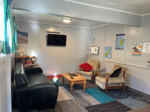 a living room with a couch and chairs and a tv at Fairlie Holiday Park in Fairlie