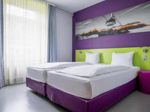 ein lila-grünes Schlafzimmer mit zwei Betten in der Unterkunft ibis Styles Luzern in Luzern