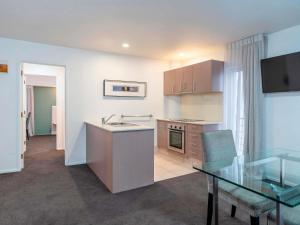 a kitchen and dining room with a glass table at Mantra Central Wellington in Wellington