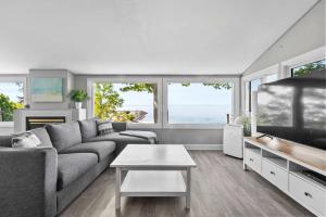 a living room with a couch and a tv at Crystal Beach Waterfront Cottage - Sunset Views in Fort Erie