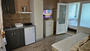 a kitchen with a sink and a room with a bed at Apartmani Eli SA DVORIŠTEM in Veliko Gradište