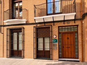 a brick building with two entrances and a door at Las 9 Candelas alojamiento en el centro de Yecla in Yecla