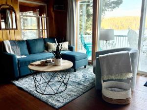 a living room with a blue couch and a table at Lakefront Cabin Dock Kayaks & Fire Pit in Hayden +22 photos