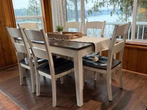 a dining room table with four chairs and a window at Lakefront Cabin Dock Kayaks & Fire Pit in Hayden