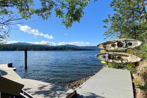 a boat sitting on a dock on a lake at Lakefront Cabin Dock Kayaks & Fire Pit in Hayden