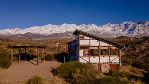 a house in the desert with mountains in the background at Cabaña El Cóndor in Potrerillos