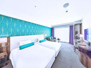 a hotel room with two beds and a desk at Mercure Okinawa Naha in Naha +265 photos
