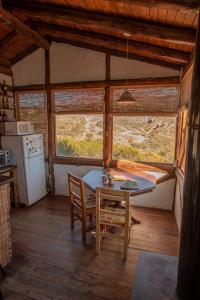 a kitchen with a table and chairs in a room at Cabaña El Cóndor in Potrerillos