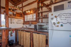 a kitchen with a refrigerator and a microwave at Cabaña El Cóndor in Potrerillos +9 photos