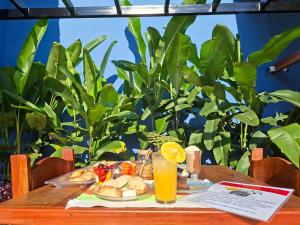 a table with a plate of food and orange juice at Pousada Aroma de Café em Socorro-SP in Socorro +98 photos