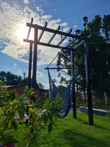 a hammock in a garden with the sun in the background at Pousada Aroma de Café em Socorro-SP in Socorro