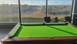 a green pool table in front of a window at Diamond Blue in Sidi Rahal