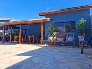 a patio with tables and chairs outside of a building at Pousada Aroma de Café em Socorro-SP in Socorro