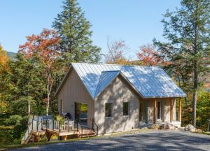 a barn style house with a metal roof at Private Nordic Spa Retreat - Mont-Tremblant in Lac-Superieur