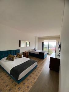 a hotel room with two beds and a television at VILLA DEL ROSARIO in Tena