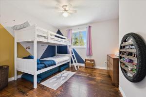 a bedroom with a bunk bed and a ceiling fan at Larkwhistle Sauna Chickens Near BEACHES in Wiarton