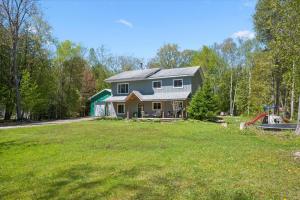 a house with a green lawn in front of it at Larkwhistle Sauna Chickens Near BEACHES in Wiarton
