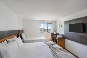 a bedroom with a bed and a flat screen tv at Plaza Suíte Natal Vista Mar in Natal +13 photos