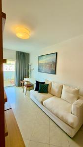 a living room with a white couch and a table at Ilumina Hostel Albufeira in Albufeira