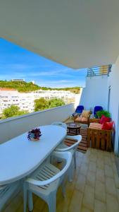 a balcony with a table and chairs and a couch at Ilumina Hostel Albufeira in Albufeira